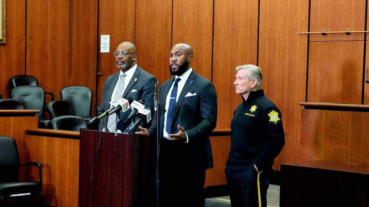 City of Columbia Tyler Bailey, flanked by 5th Circuit Solicitor Byron Gipson and Richland County Sheriff Leon Lott, speaks to reporters about a new program designed to aid parents in dealing with their children committing crime.
