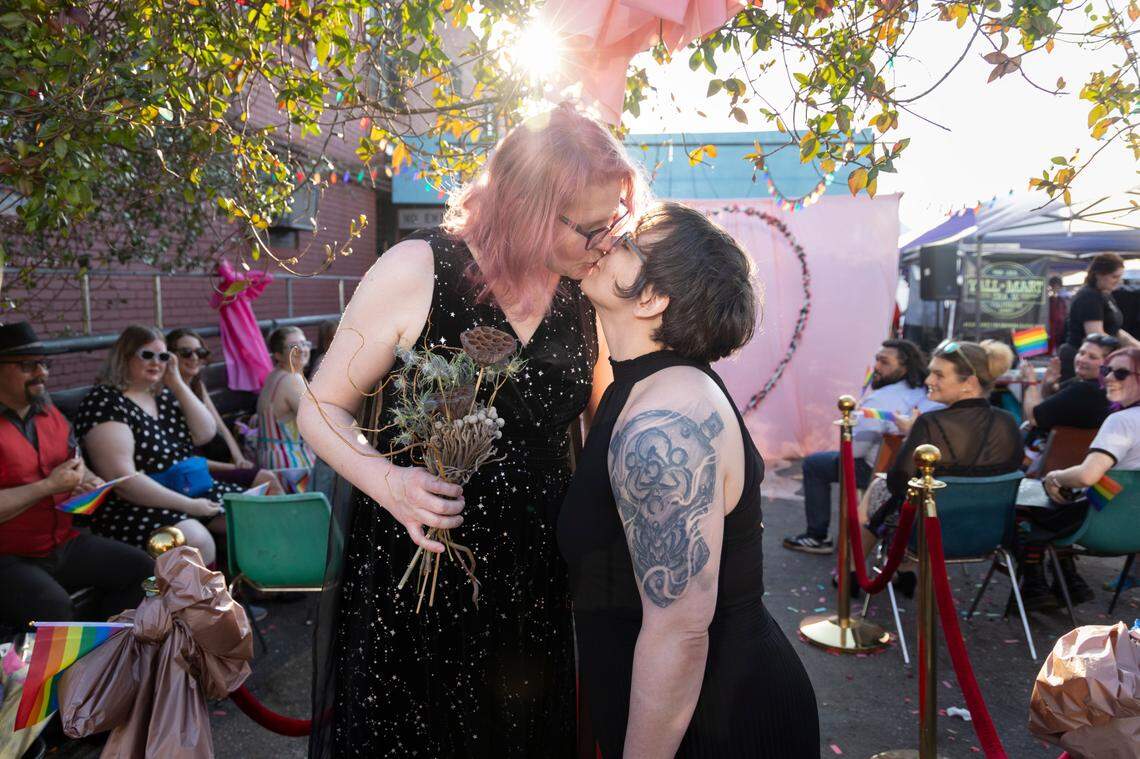 Christine Fowler and her wife Sharon Thrailkill kiss after their wedding at Y’all-Mart, a quarterly art fair series, at Art Bar in Columbia, South Carolina on Sunday, February 9, 2025. Y’all-Mart hosted eight gay weddings at the art fair as a fundraiser for the Harriet Hancock Center’s name change fund and as a way for LGBT couples to get the legal protection of marriage quickly.