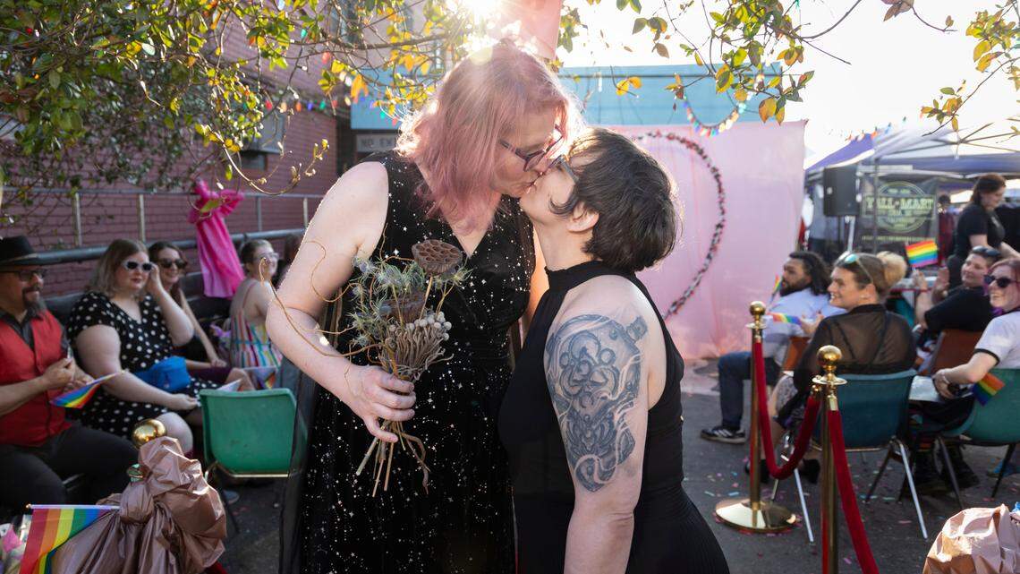Christine Fowler and her wife Sharon Thrailkill kiss after their wedding at Y’all-Mart, a quarterly art fair series, at Art Bar in Columbia, South Carolina on Sunday, February 9, 2025. Y’all-Mart hosted eight gay weddings at the art fair as a fundraiser for the Harriet Hancock Center’s name change fund and as a way for LGBT couples to get the legal protection of marriage quickly.