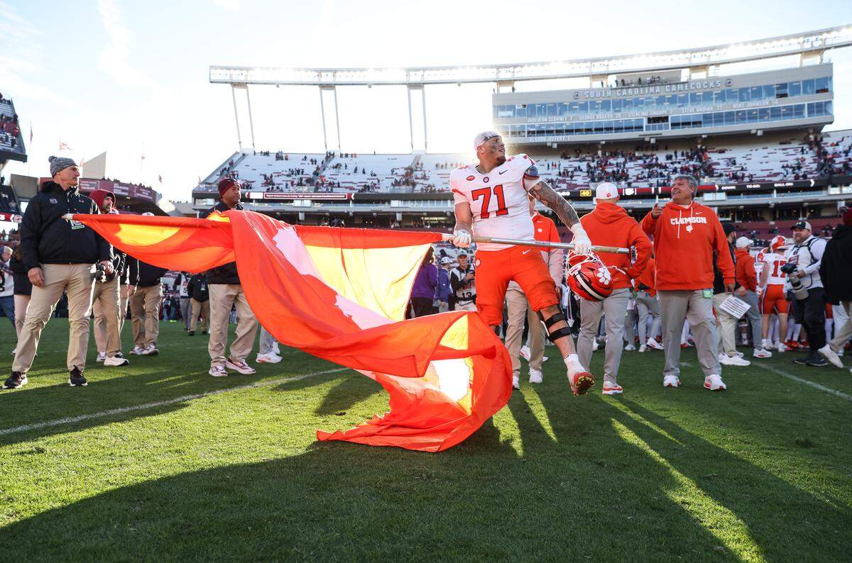 Clemson offensive lineman Tristan Leigh (71) carries a flag to midfield following South Carolina’s loss to Clemson at Williams-Brice Stadium in Columbia on Saturday, November 29, 2025.