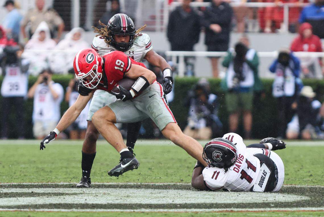 South Carolina linebacker Debo Williams (0) and defensive lineman Elijah Davis (11) trip up Georgia tight end Brock Bowers (19) during the second half of the Gamecocks’ game at Sanford Stadium in Athens on Saturday, September 16, 2023.