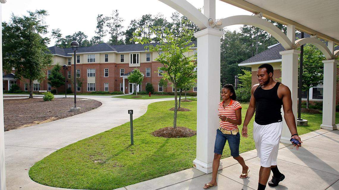 Francis Marion University sophomores, Larita Dingle, of Manning, and Kevin Inyangetor, of Columbia, make their way by the school’s dormitoris, The Forest Villas, which were completed in 2007.