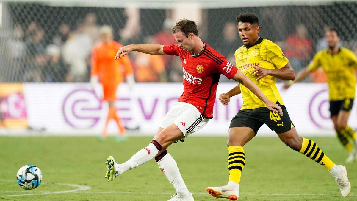 Manchester United defender Jonny Evans (27) kicks the ball against Borussia Dortmund forward Paul-Phillip Besong (49) in July 2023 at Allegiant Stadium in Las Vegas.