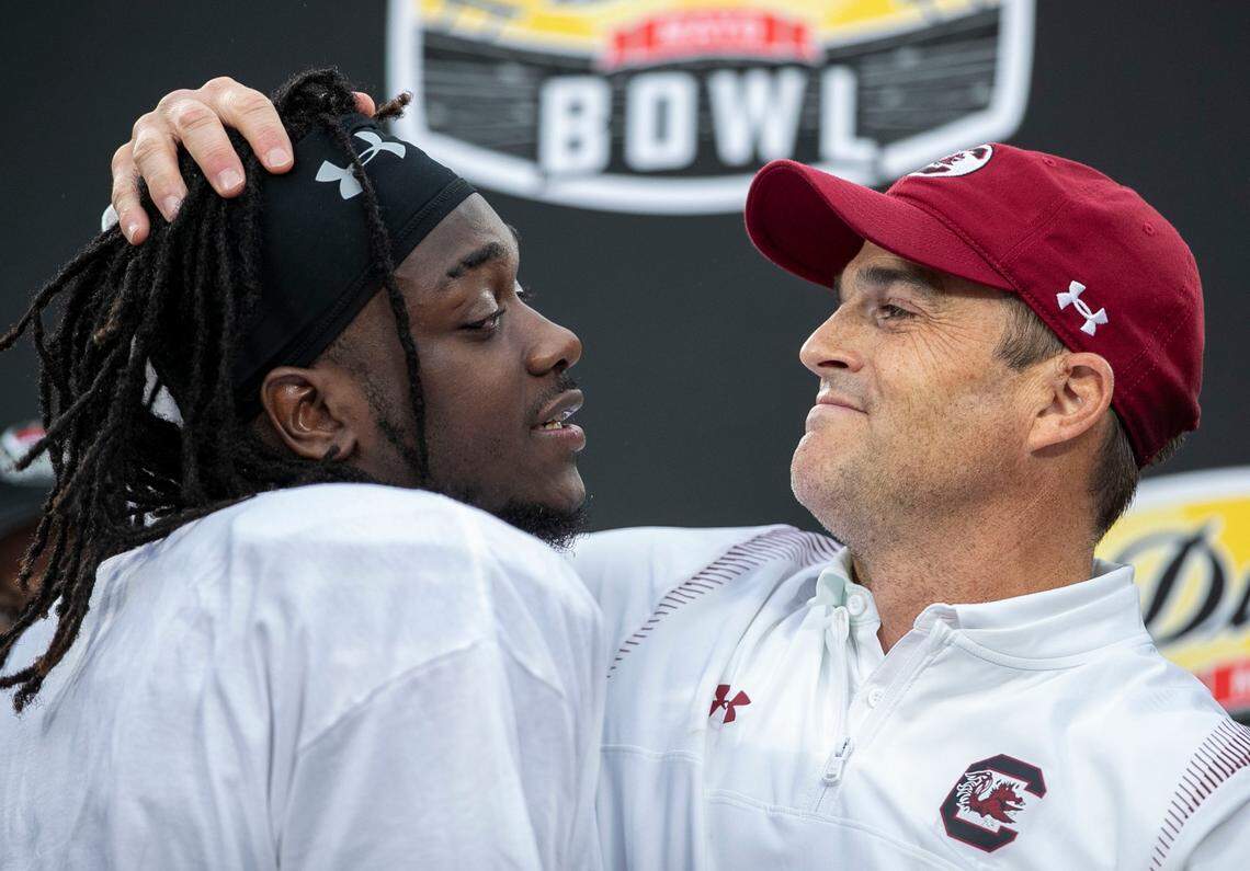 South Carolina coach Shane Beamer embraces wide receiver Dakereon Joyner (5) during the trophy presentation following the Gamecocks’ victory over North Carolina in the Duke’s Mayo Bowl on Thursday, December 30, 2021 at Bank of America Stadium in Charlotte, N.C.