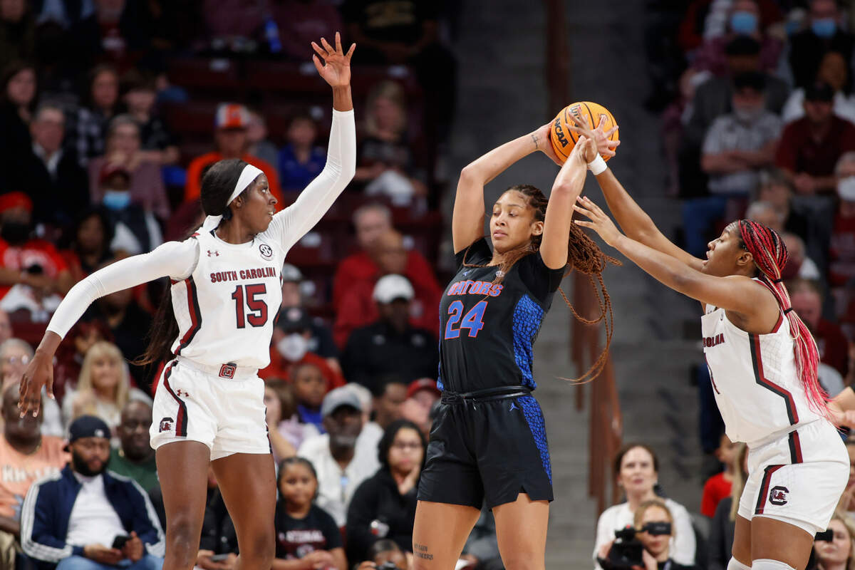 Florida center Ra Shaya Kyle (24) looks to pass the ball against South Carolina forwards Aliyah Boston, right, and Laeticia Amihere (15) during the first half of an NCAA college basketball game in Columbia, S.C., Thursday, Feb. 16, 2023. (AP Photo/Nell Redmond)