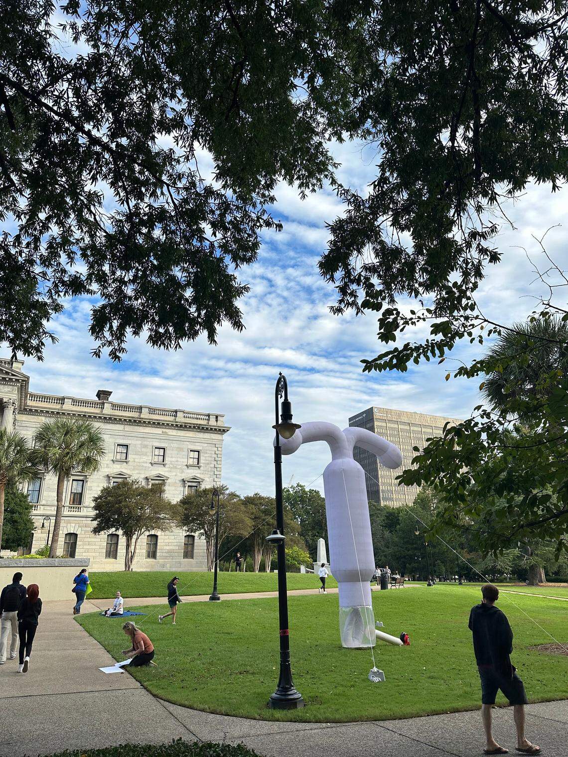 A 20-foot fake IUD towers over protesters at the South Carolina statehouse on Wednesday, Oct. 1, 2025 in Columbia.