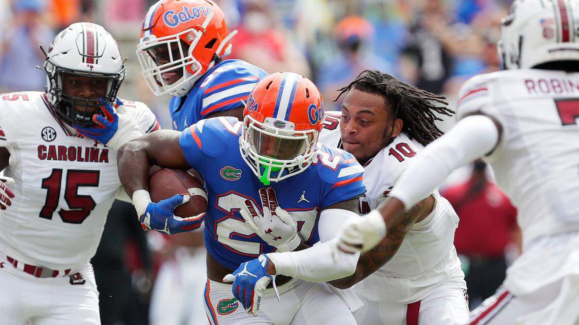 Florida running back Dameon Pierce (27) is tackled by helmet less South Carolina defensive back RL Roderick (10) during an NCAA college football game in Gainesville, Fla., Saturday, Oct. 3, 2020. (Brad McClenny/The Gainesville Sun via AP, Pool)