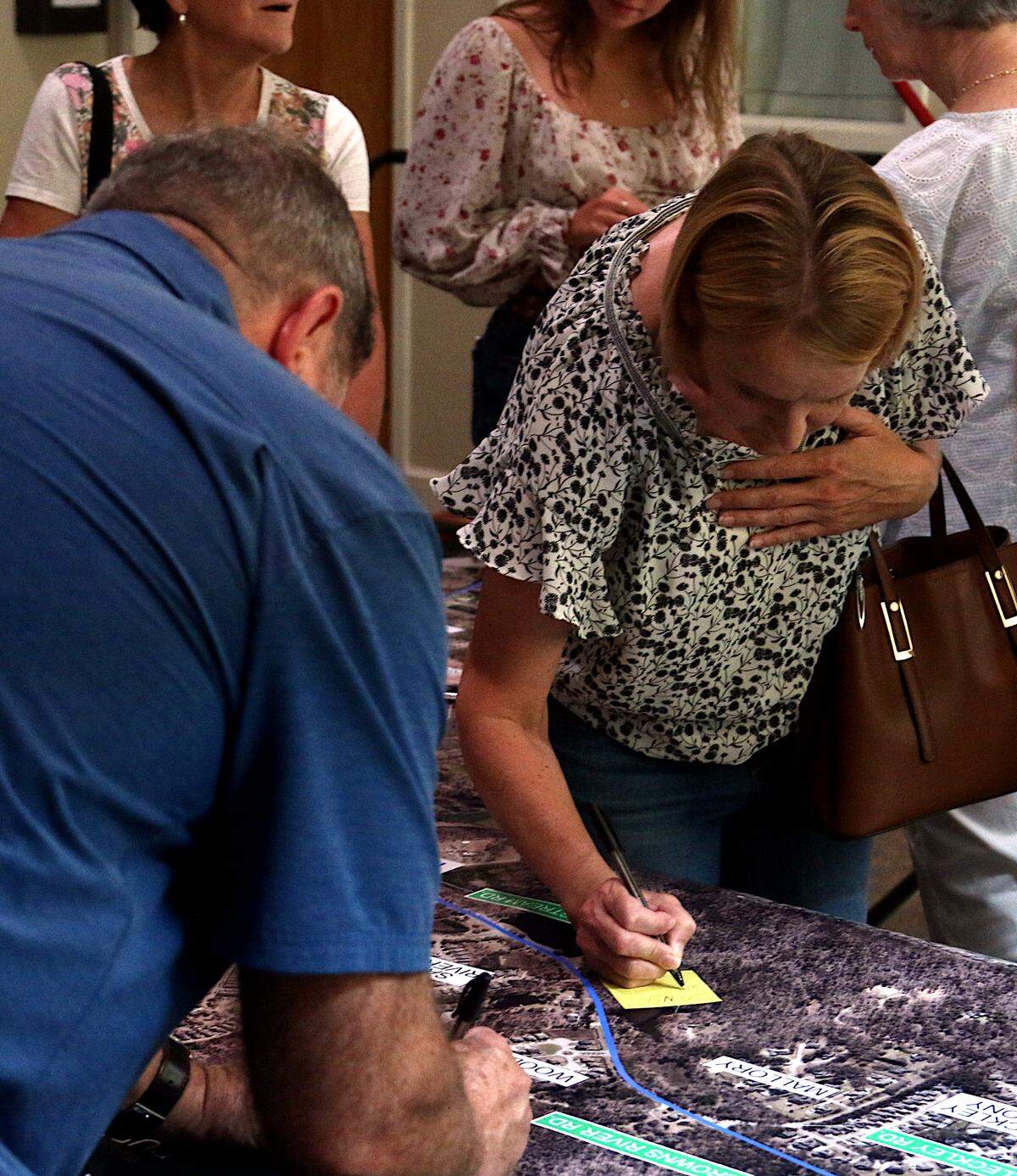 Residents attach their thoughts on improving Corley Mill Road to large maps at a recent public meeting at Riverbend Community Church. Aug. 1, 2024