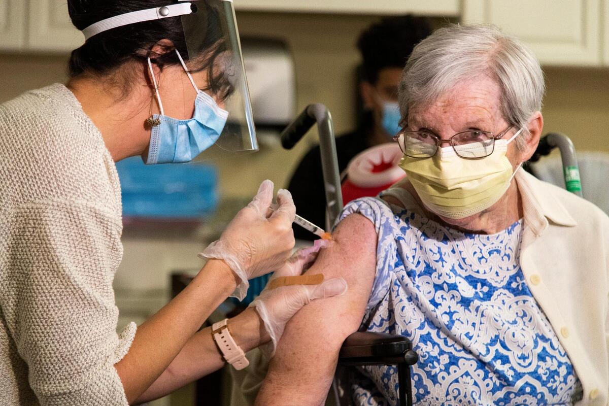 Nora Schafer receives the first shot of the coronavirus vaccine from Dr. Jennifer Henzler at Wellmore of Lexington on Wednesday, December 30, 2020. Schafer is looking forward to seeing her son after she is fulling vaccinated.