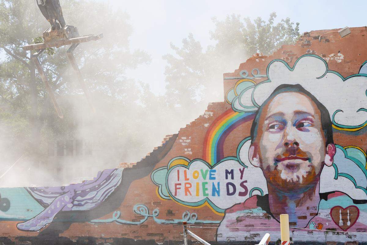 A mural of Aaron Graves, a local musician who died in 2019 of cancer, on the side of the Hunter-Gartherer location on South Main Street in Columbia, South Carolina is deconstructed on Saturday, June 28, 2025. Teams of volunteers assisted organizing pieces of the building for resale, and helped preserving the mural of Aaron Graves, a local musician who died of cancer in 2019. 