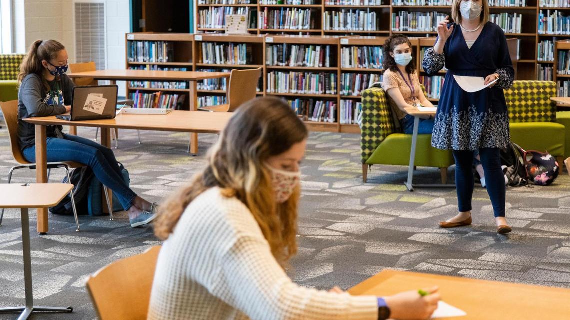 Kayla Hostetler teaches her English IV Honors class at Aiken High School on Tuesday, March 23, 2021. The class meets in the library occasionally and students sit six feet apart.