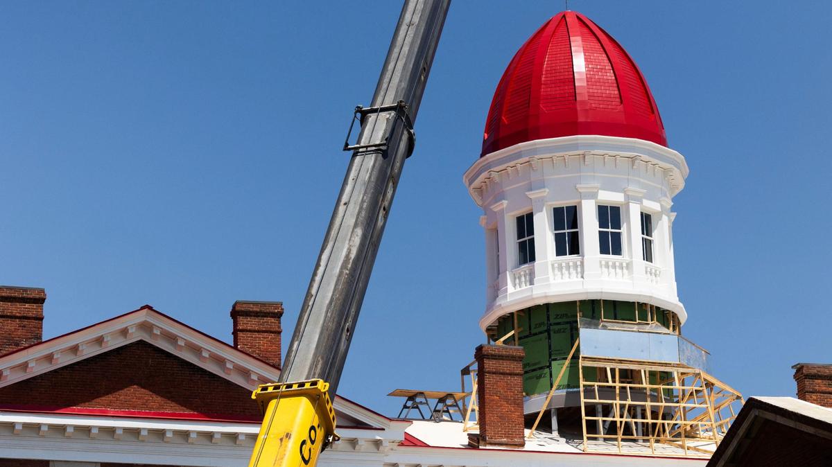 Workers install the new cupola dome at the Babcock building on Friday, August 18, 2023.