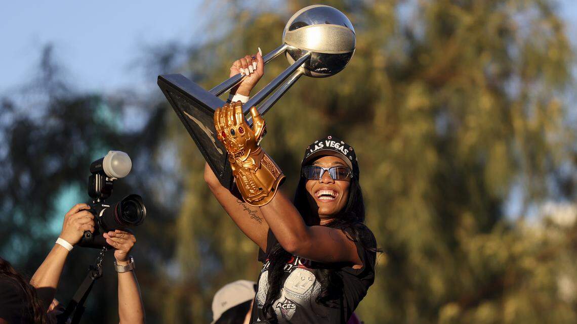 A'ja Wilson of the Las Vegas Aces lifts the 2025 WNBA championship trophy as she rides on top of a bus during the team's championship parade at Toshiba Plaza on Oct. 17, 2025 in Las Vegas, Nevada. 