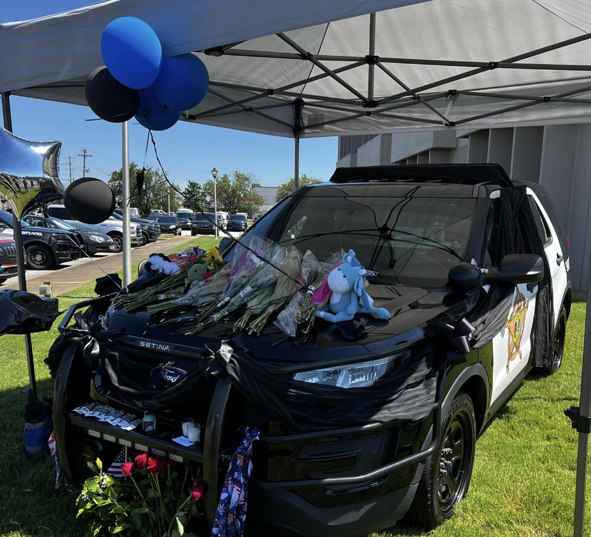 People have left tributes to Deputy Austin Aldridge on his patrol car parked outside the Spartanburg County Sheriff’s office.