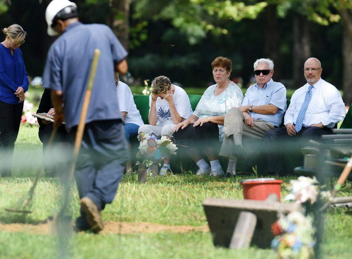In this file photo, Penny Lovett Lakoskey drops her head as cemetery workers finish reburying the remains of her daughter, Tina Lovett, on Aug. 31, 2017. Tina Lovett was 17 when she was murdered in 1984 seven miles from her Jacksonville, FL home. Her family believed they had buried all of her badly decomposed remains at Riverside Memorial Park. But they were shocked to learn 33 years later that the majority of her remains had instead been shuffled between various agencies around Florida before being returned to the Jacksonville Medical Examiner’s office.