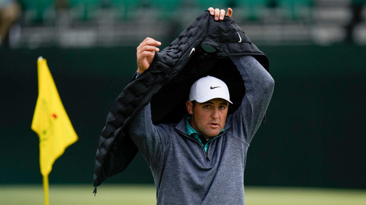 Scottie Scheffler puts on a vest on the fifth hole during the third round at the Masters golf tournament on Saturday, April 9, 2022, in Augusta, Ga. (AP Photo/Jae C. Hong)