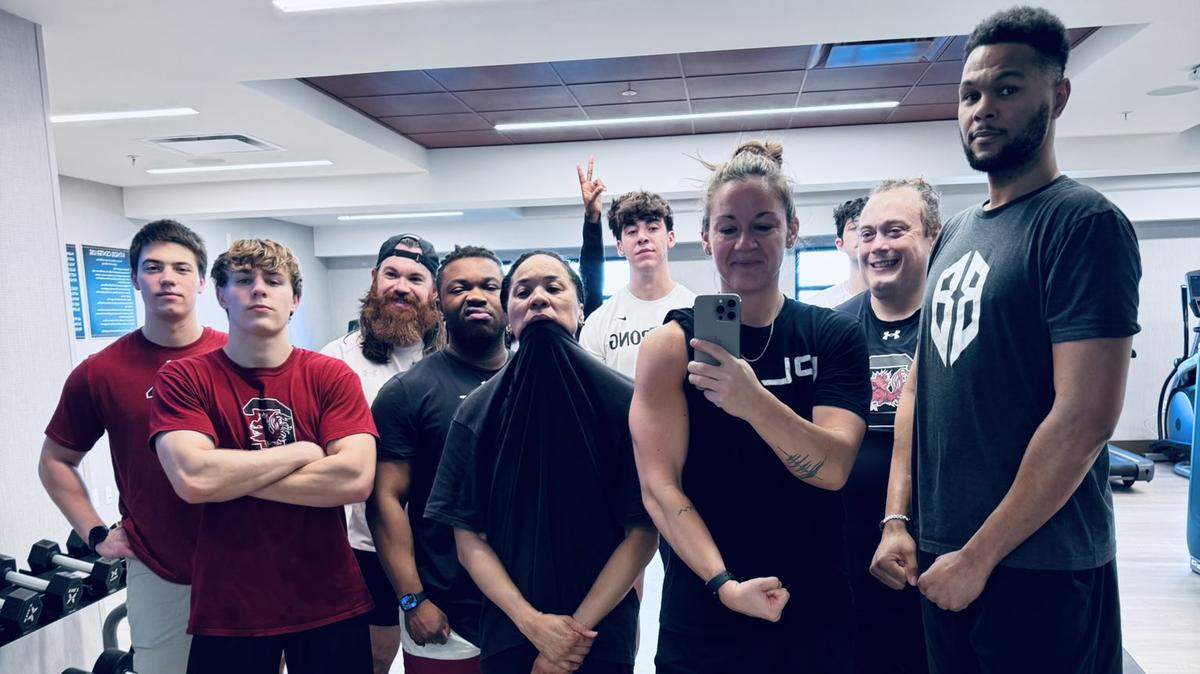 South Carolina WBB sports performance coach Molly Binetti surrounded by head coach Dawn Staley and other members of the Gamecocks coaching/support staff at their regular pregame workout in March 2026.