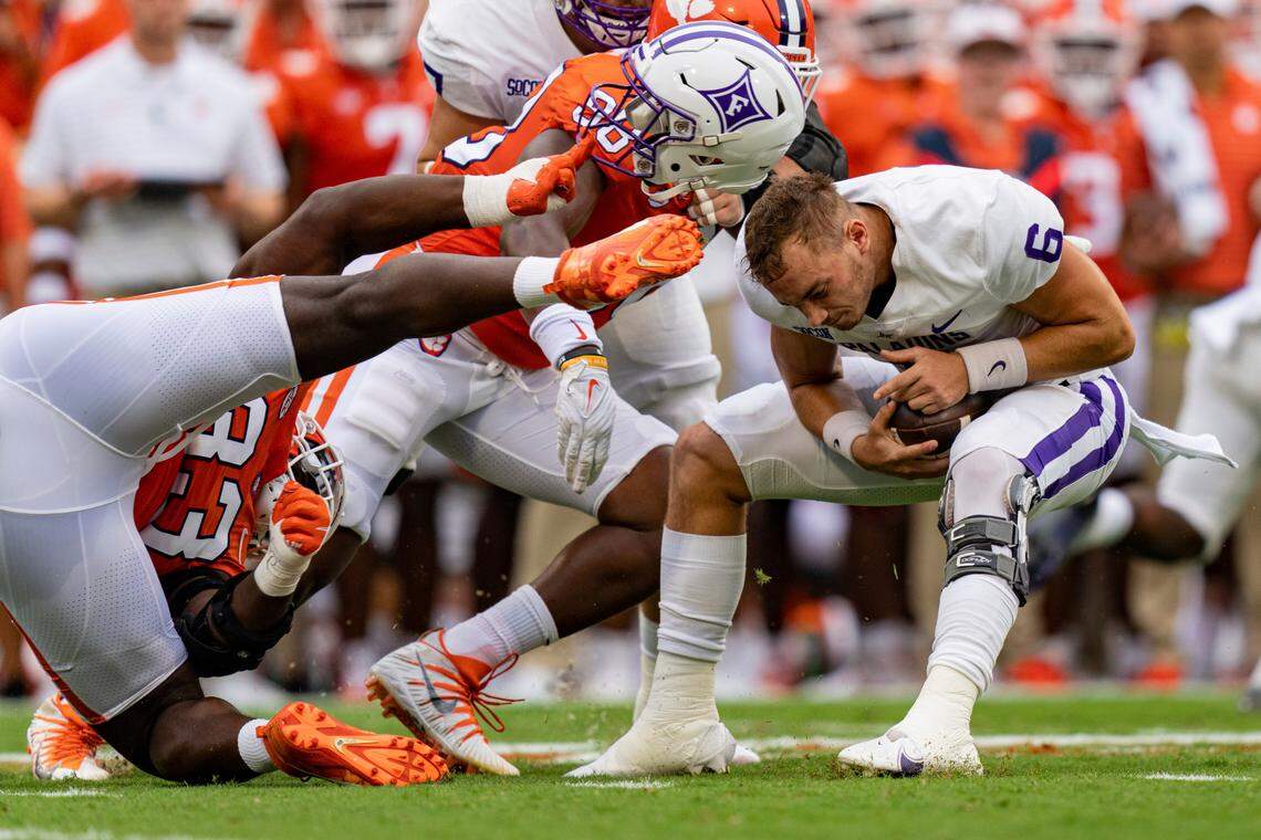 Clemson Tigers defensive tackle Ruke Orhorhoro pulls off the helmet of Furman Paladins quarterback Tyler Huff (6) in the first quarter during an NCAA college football game in Clemson, S.C., Saturday, Sept. 10, 2022. (AP Photo/Jacob Kupferman)