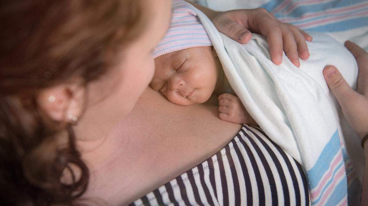 A mother holds her newborn baby.