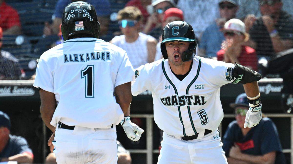 Coastal Carolina Chanticleers third baseman Walker Mitchell (5) celebrates as left fielder Sebastian Alexander (1) scores against the Arizona Wildcats during the eighth inning at Charles Schwab Field. 