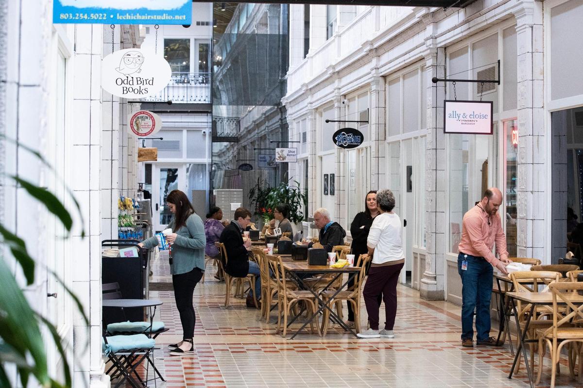 People eat salads and sandwiches outside Swanson’s Deli on Friday, March 25, 2022. The Arcade Mall is home to several small businesses, including a new book store, coffee shop and tattoo parlor.