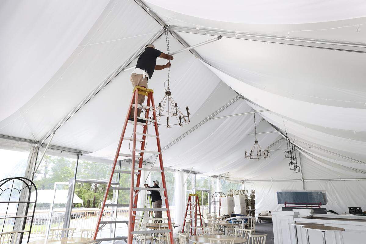 Pancho Gil with Crisp Event Rentals hangs a light inside the Champions Club tent at Woodcreek Club on Thursday, May 7. The course is hosting the Korn Ferry Tour’s Colonial Life Charity Classic golf tournament starting on Thursday, May 14.