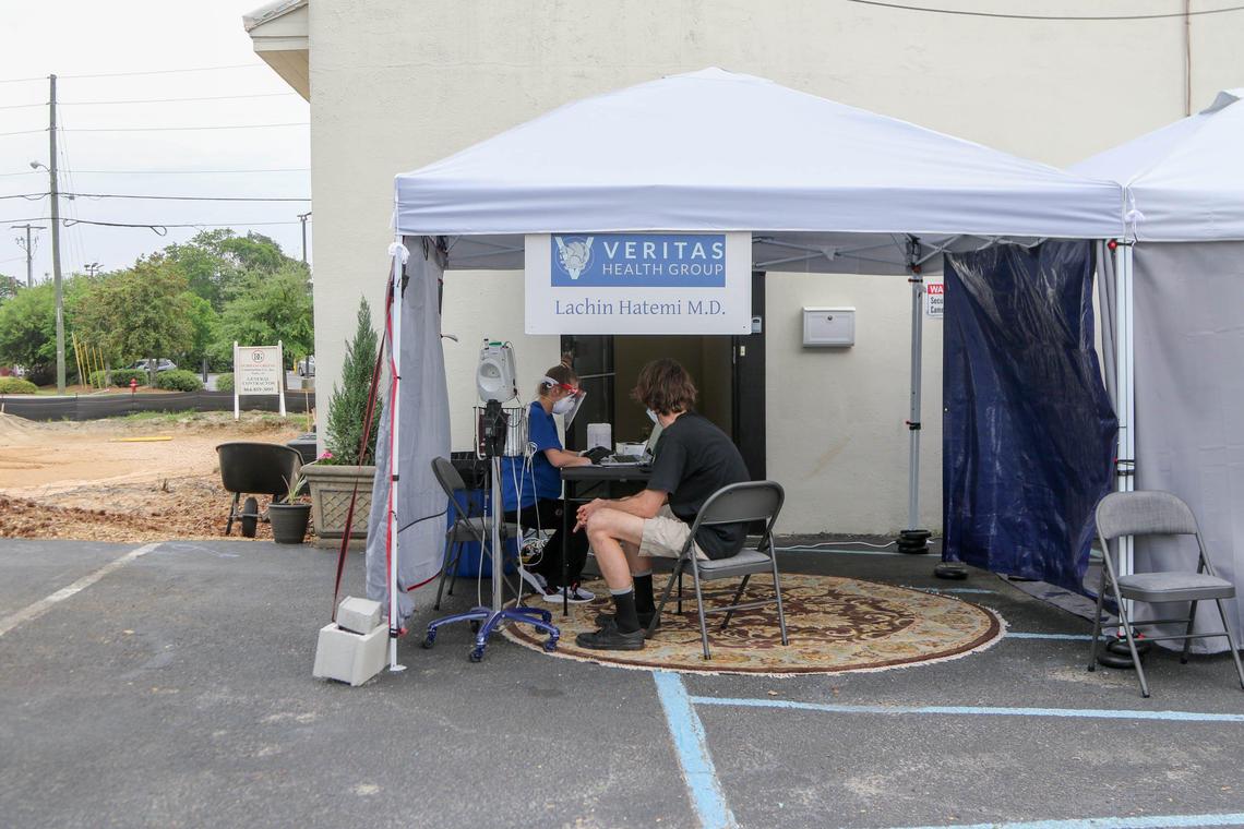 Lindsey Greer, a lead medical technician at Veritas Health Group in Lexington, processes a patient to be tested for the coronavirus at a tent outside the urgent care clinic. They test about 20-30 patients a day for the coronavirus. 4/8/20