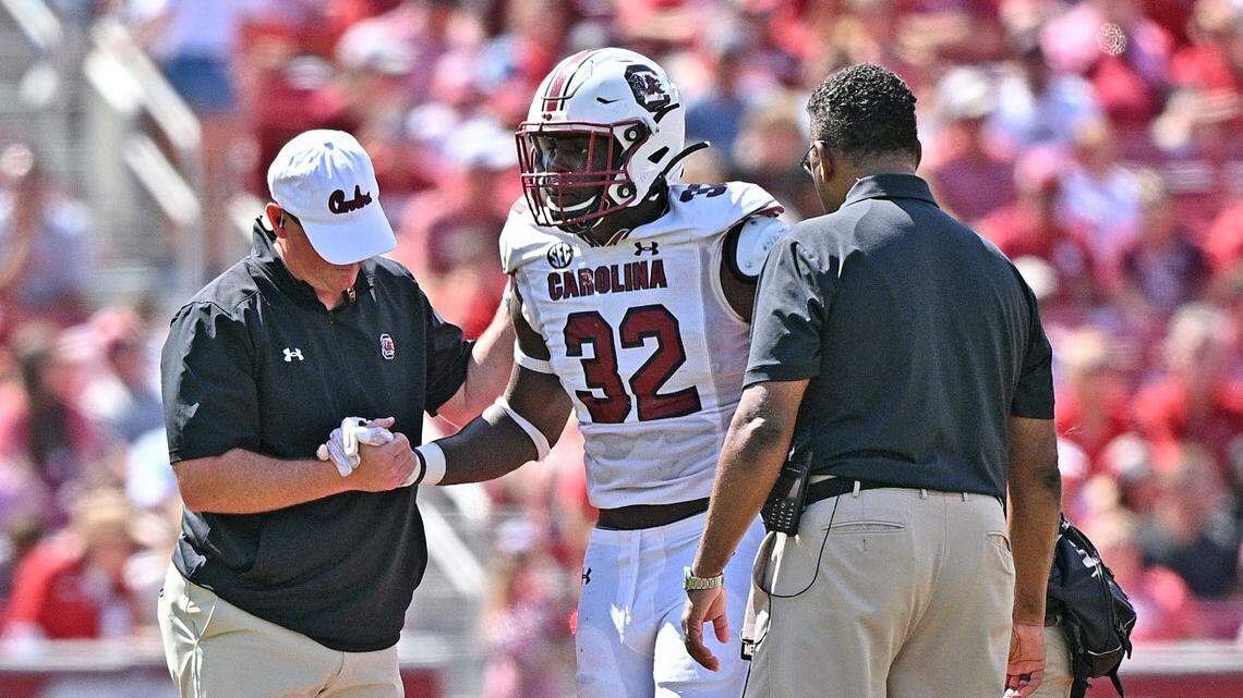 South Carolina Linebacker Mo Kaba (32) getting assistance from training staff at Donald W. Reynolds Razorback Stadium in Fayetteville, Arkansas on Sept. 10, 2022.