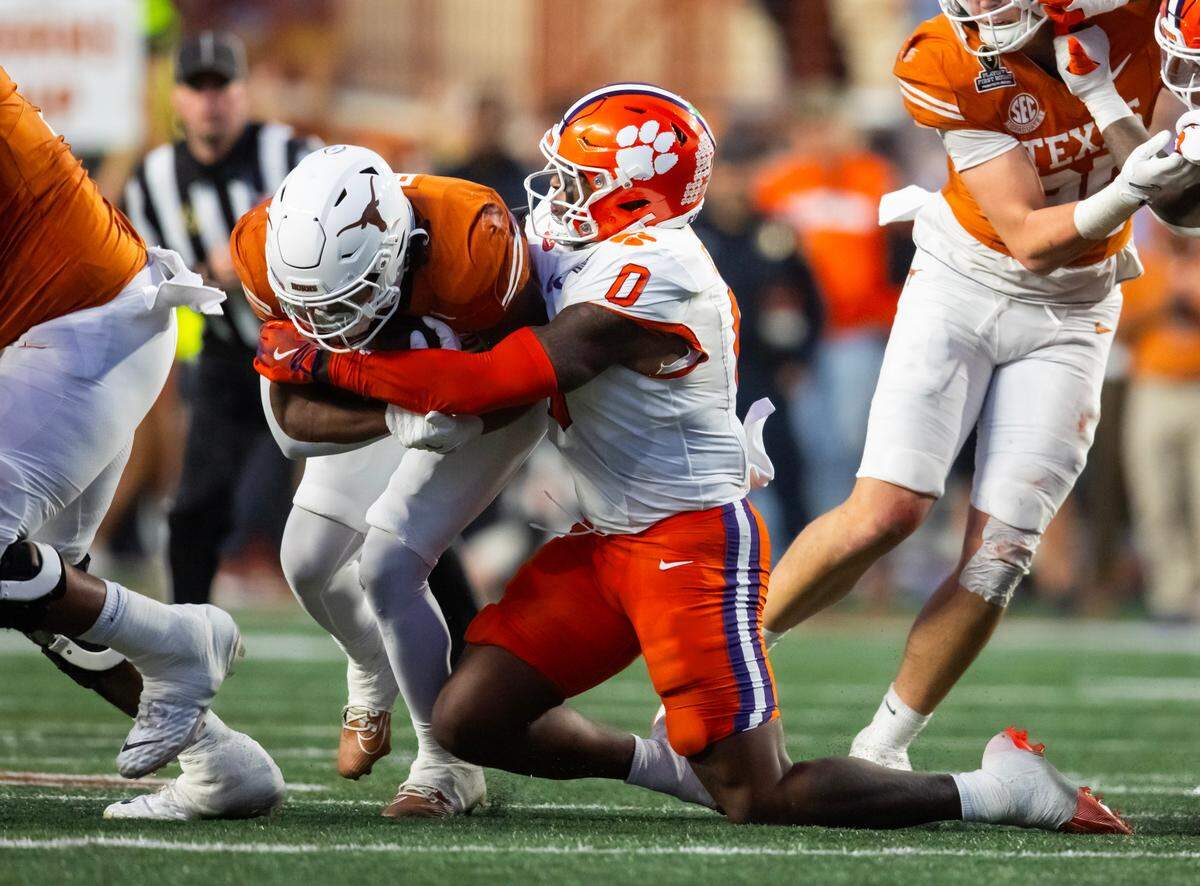 Dec 21, 2024; Austin, Texas, USA; Clemson Tigers linebacker Barrett Carter (0) tackles Texas Longhorns running back Jaydon Blue (23) during the CFP National playoff first round at Darrell K Royal-Texas Memorial Stadium.