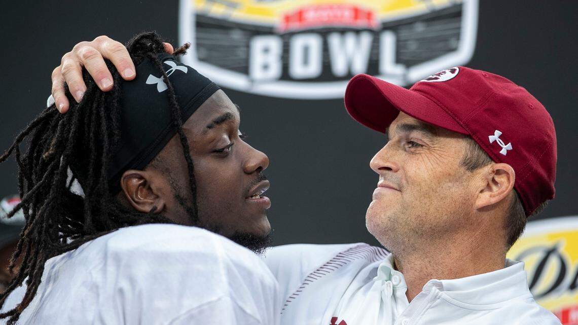 South Carolina coach Shane Beamer embraces wide receiver Dakereon Joyner (5) during the trophy presentation following the Gamecocks’ victory over North Carolina in the Duke’s Mayo Bowl on Thursday, December 30, 2021 at Bank of America Stadium in Charlotte, N.C.