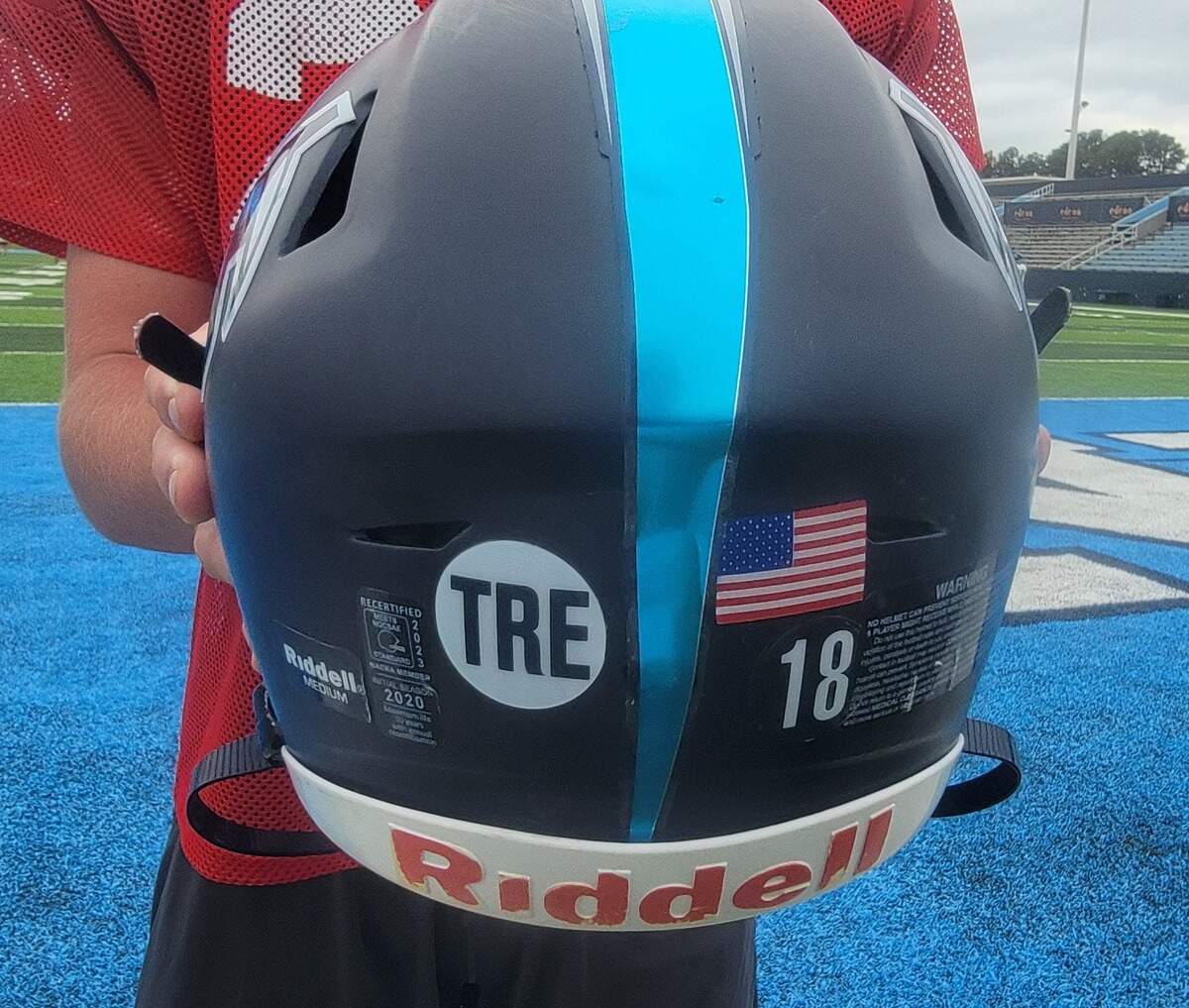 Chapin quarterback Brady Albro holds up a helmet with “TRE” sticker on it. The sticker is for Chapin defensive lineman Tre Ruff, who died on Aug. 23.
