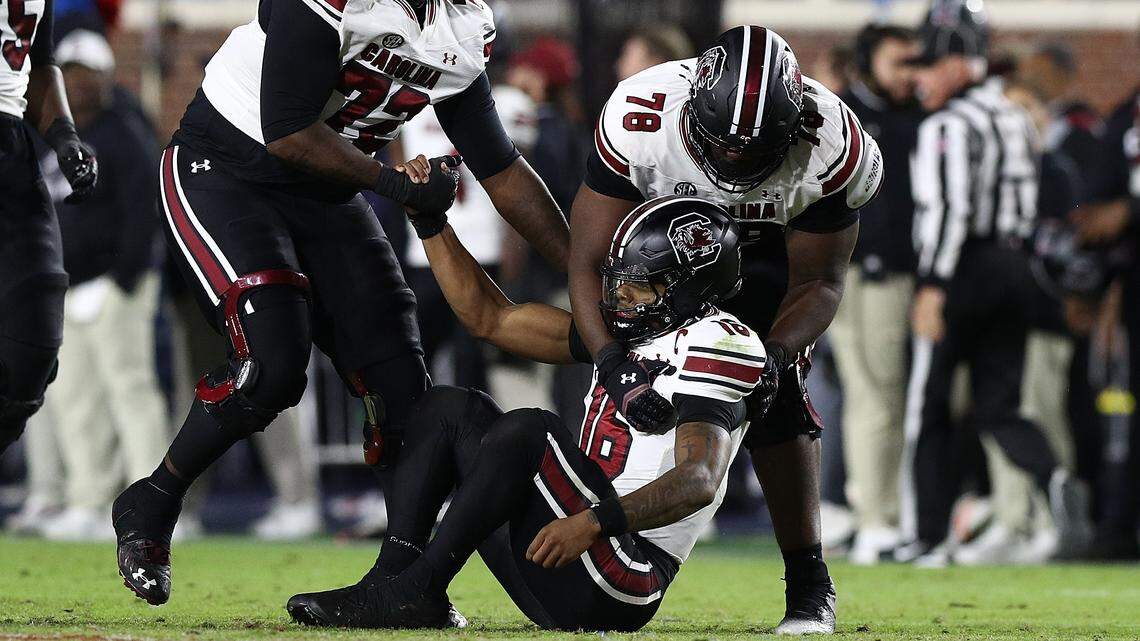 Lanorris Sellers #16 of the South Carolina Gamecocks is helped up Shedrick Sarratt Jr. #72 of the South Carolina Gamecocks and Trovon Baugh #78 of the South Carolina Gamecocks during the second half in the game against Ole Miss at Vaught-Hemingway Stadium on November 01, 2025 in Oxford, Mississippi.