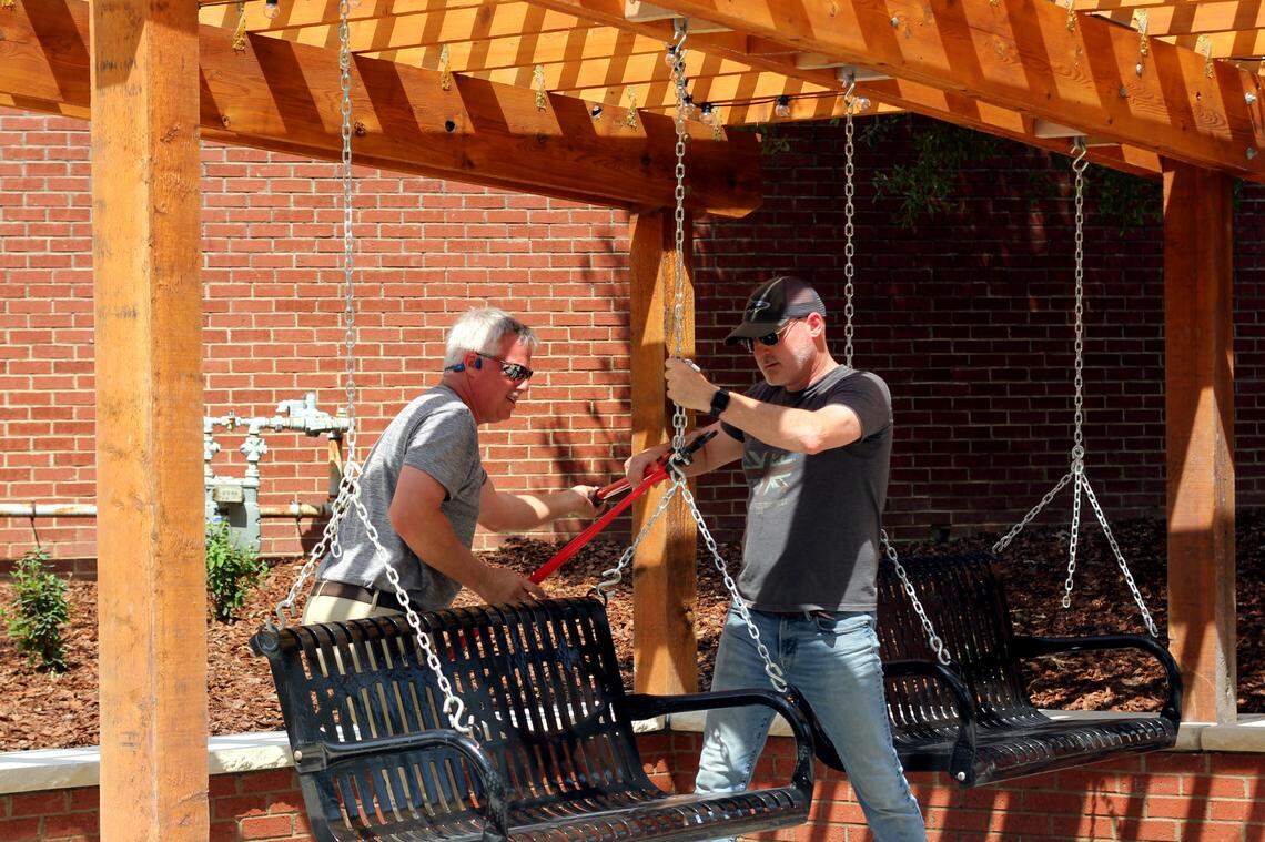 Workers finish installing a swing at Virginia Hylton Park on May 3, 2024.