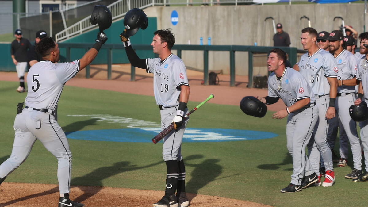 North Greenville’s Pat Monteith (5) is greeted at home plate Thursday by Josh Senter (19) and the rest of his teammates after his third inning grand slam.
