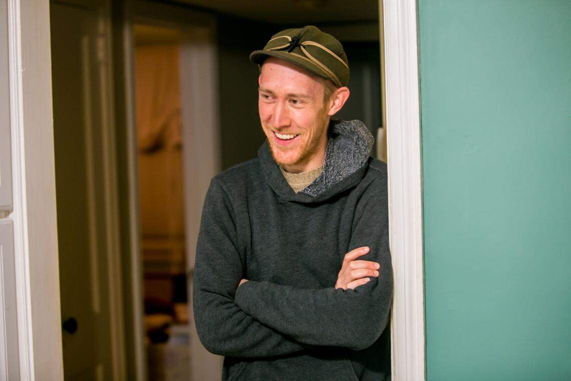 Aaron Graves watches his wife, Jessica, and daughter, Elvie, 4, cook dinner in the kitchen. Graves and his wife are local musicians (Those Lavender Whales).
