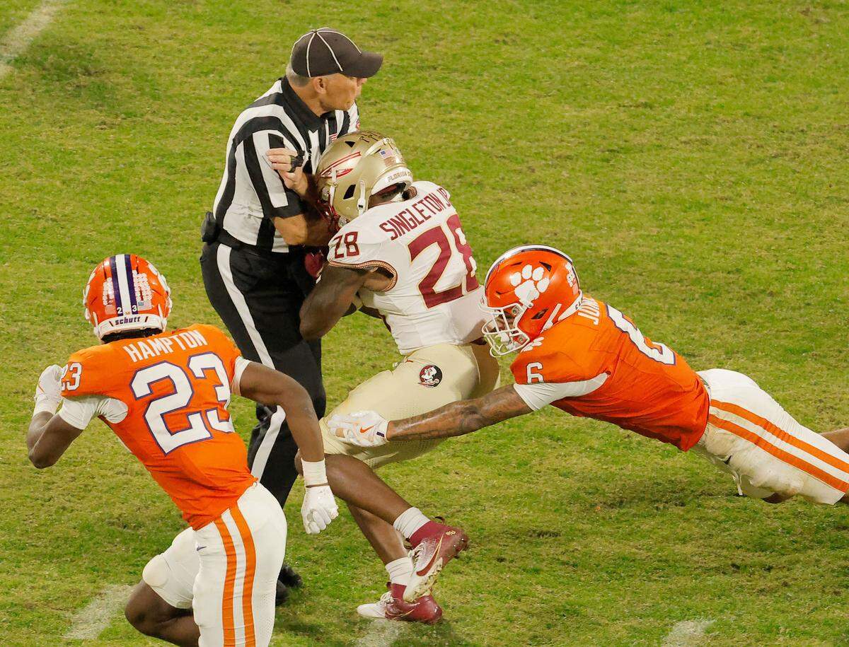 Florida State running back Samuel Singleton Jr. (28) runs into a referee as Clemson safety Ricardo Jones (6) pursues during second-half action in Clemson, S.C. on Saturday, Nov. 8, 2025. 