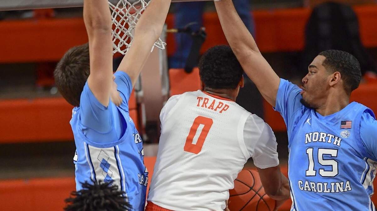 Clemson senior guard Clyde Trapp(0) shoots around North Carolina forward Walker Kessler(13), left, and North Carolina forward Garrison Brooks(15), right, during the first half Feb 2, 2021; Clemson, South Carolina, USA; at Littlejohn Coliseum.