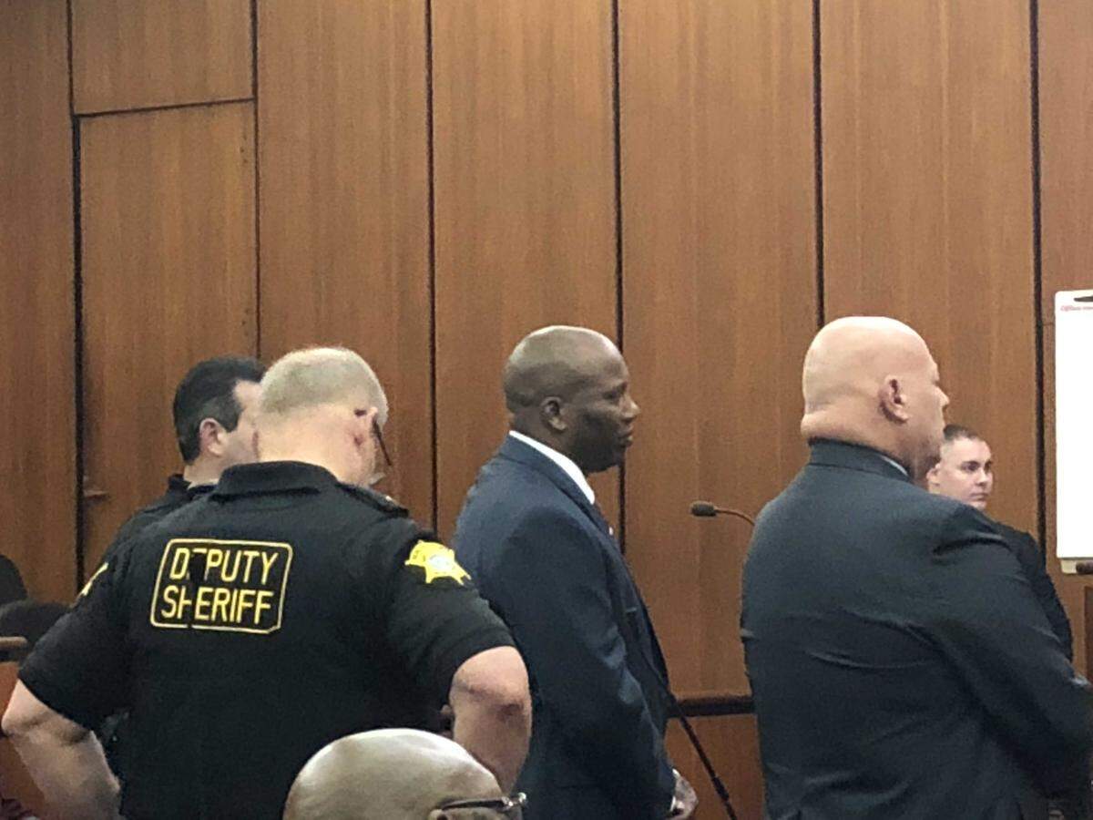 Dan Johnson (center), is arraigned in court on state embezzlement and misconduct charges in 2018.