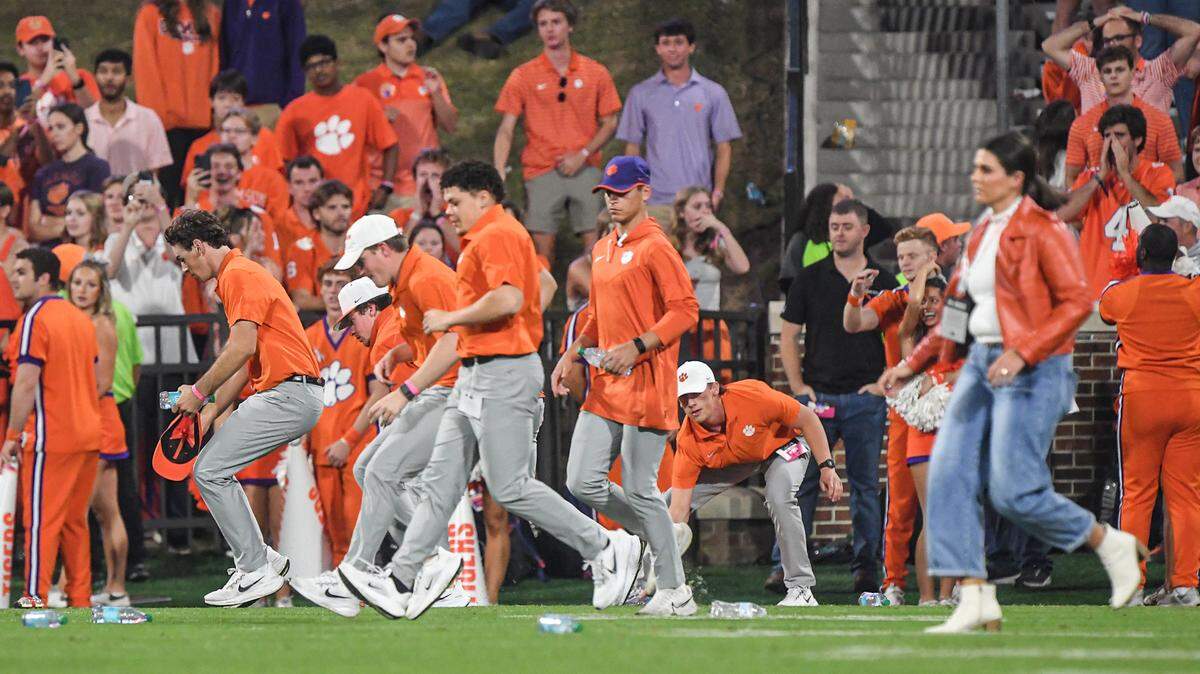 Nov 2, 2024; Clemson, South Carolina, USA; Clemson Tigers workers remove thrown water bottles after people in the stands threw some on the field after a call in favor the Louisville Cardinals during the fourth quarter at Memorial Stadium.