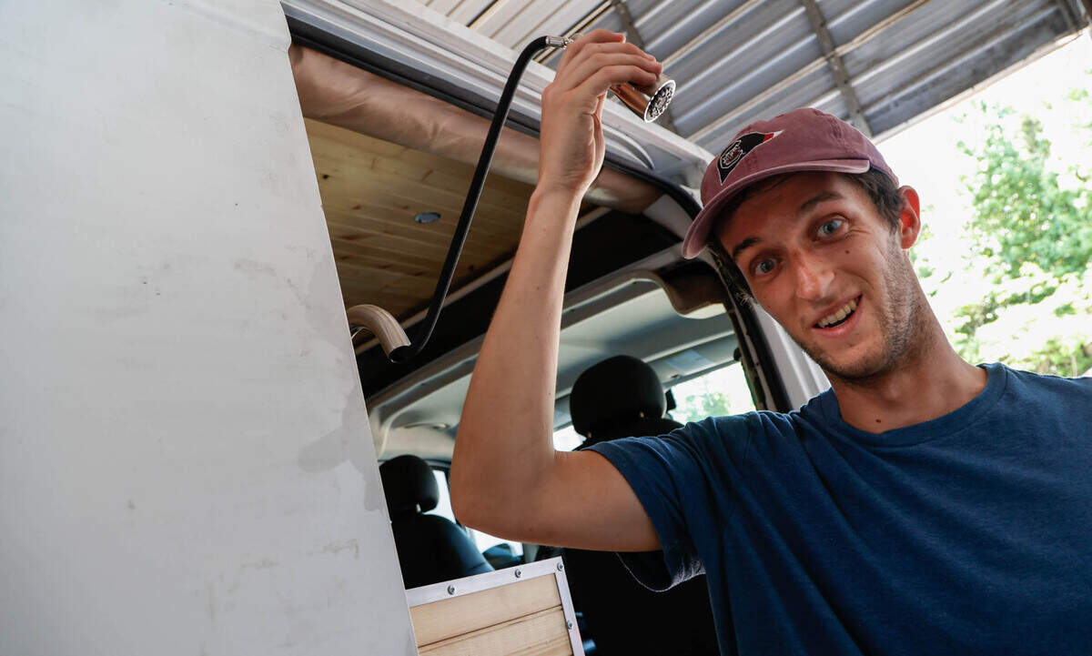 Matthew Alburn shows the kitchen faucet that can also be an outdoor shower. Alburn started a business while in school at the University of South Carolina converting cargo vans into living spaces.