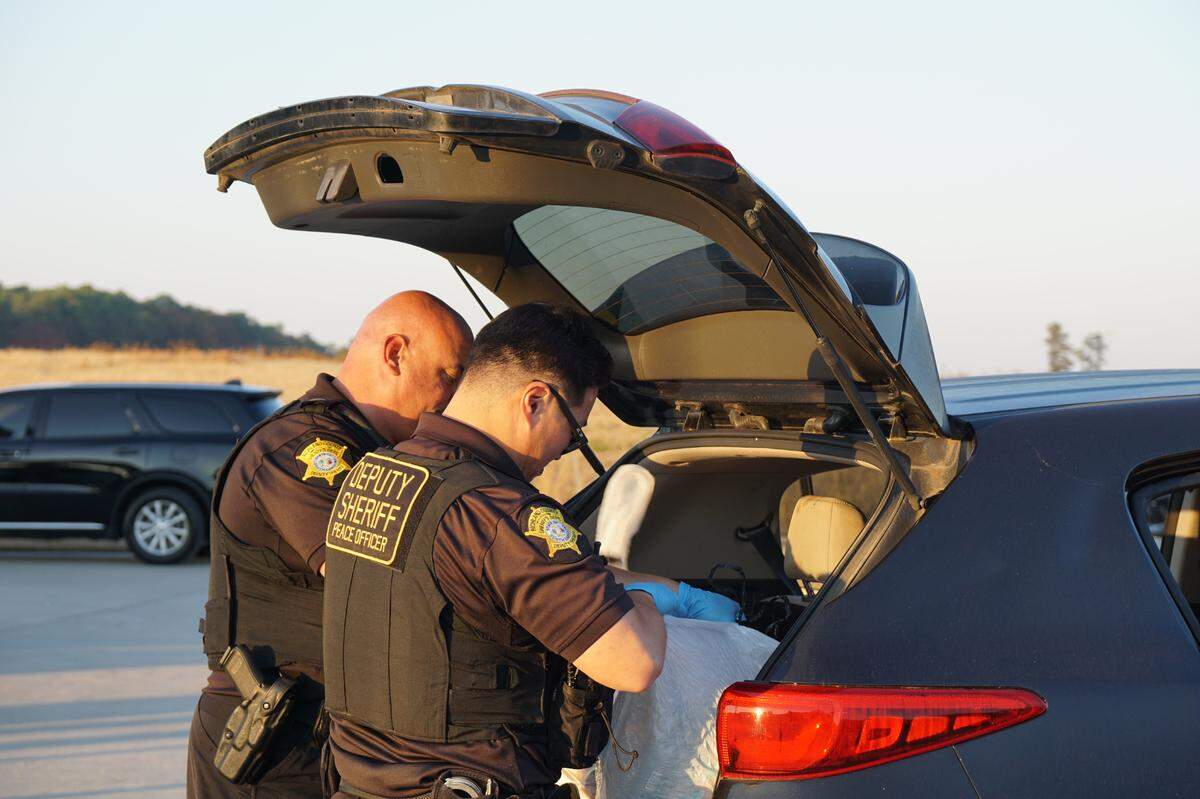 Richland County Sheriff’s Deputies hand search a car belonging to a Dept. of Corrections staff member that has been flagged by a K-9 during a sting operation.