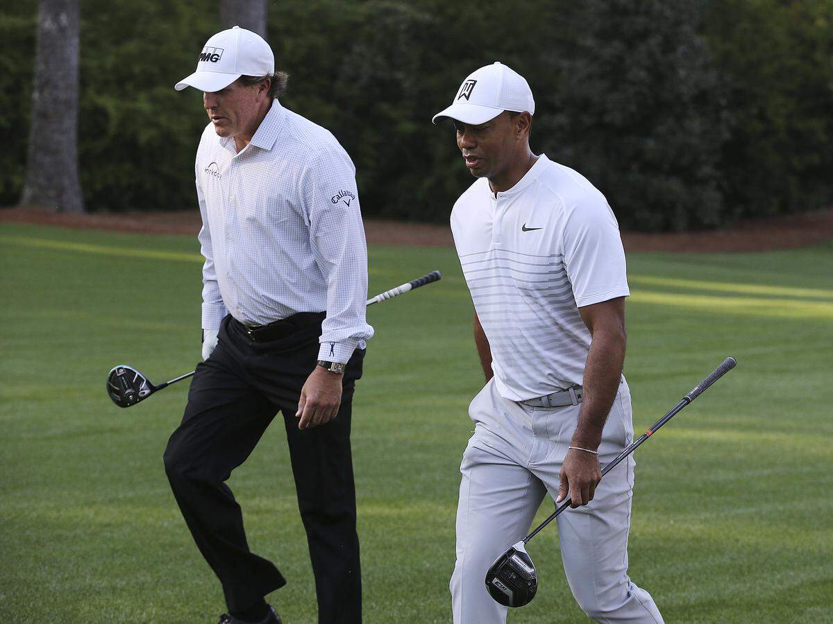 Tiger Woods and Phil Mickelson walk Augusta National Golf Club during a practice round for the 2018 Masters. While Mickelson has played the Wells Fargo Championship in Charlotte nearly every year, Woods has not played the tournament since 2012 but stands a good chance of doing so this year.