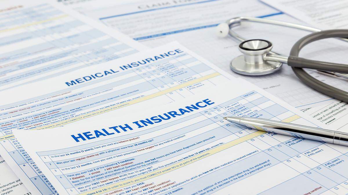 Medical insurance application, silver pen and stethoscope. Legal law contract and health insurance concepts.