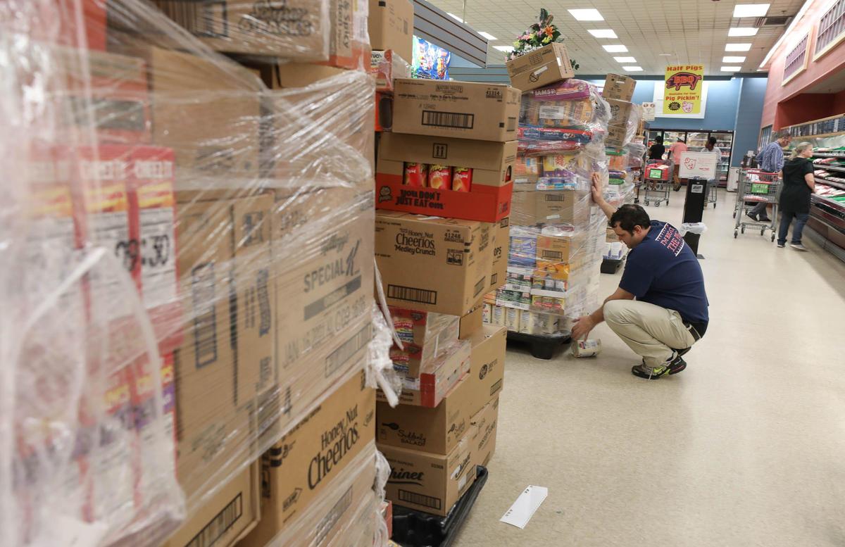 An employee unloads boxes of items delivered to a Piggly Wiggly in Columbia, SC on March 24, 2020.