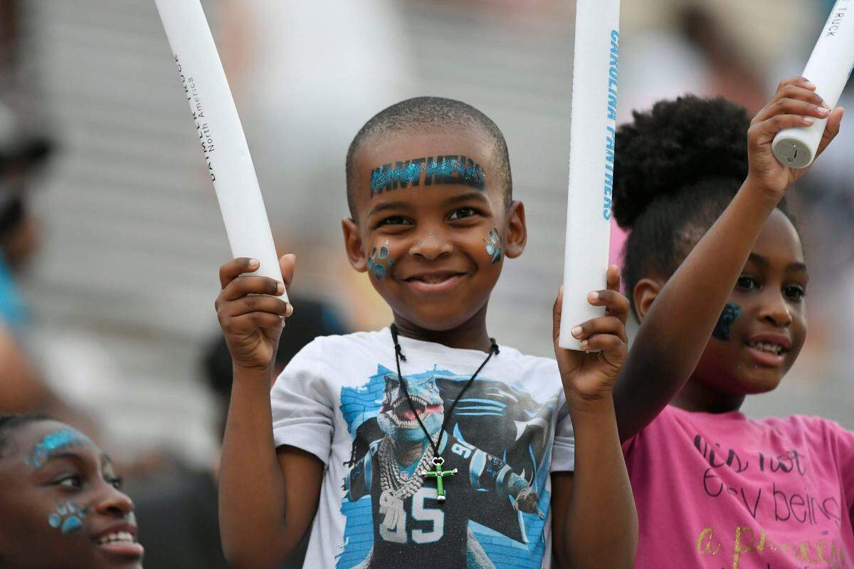 Young Carolina Panthers fans dance in the stands at Memorial Stadium during the Panthers Fan Fest in Clemson, S.C., on Thursday, Aug. 1, 2024.