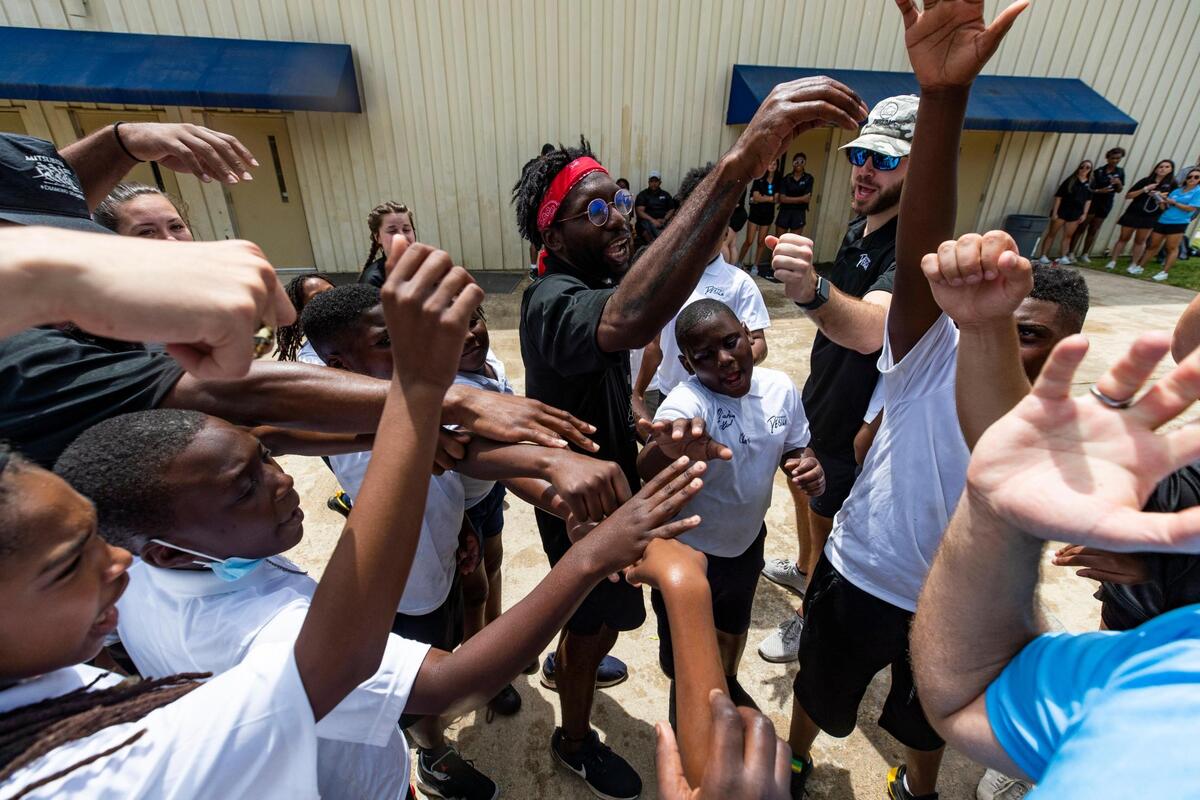 “Family!” mentors yell with participants in the Original Design football camp on Saturday.