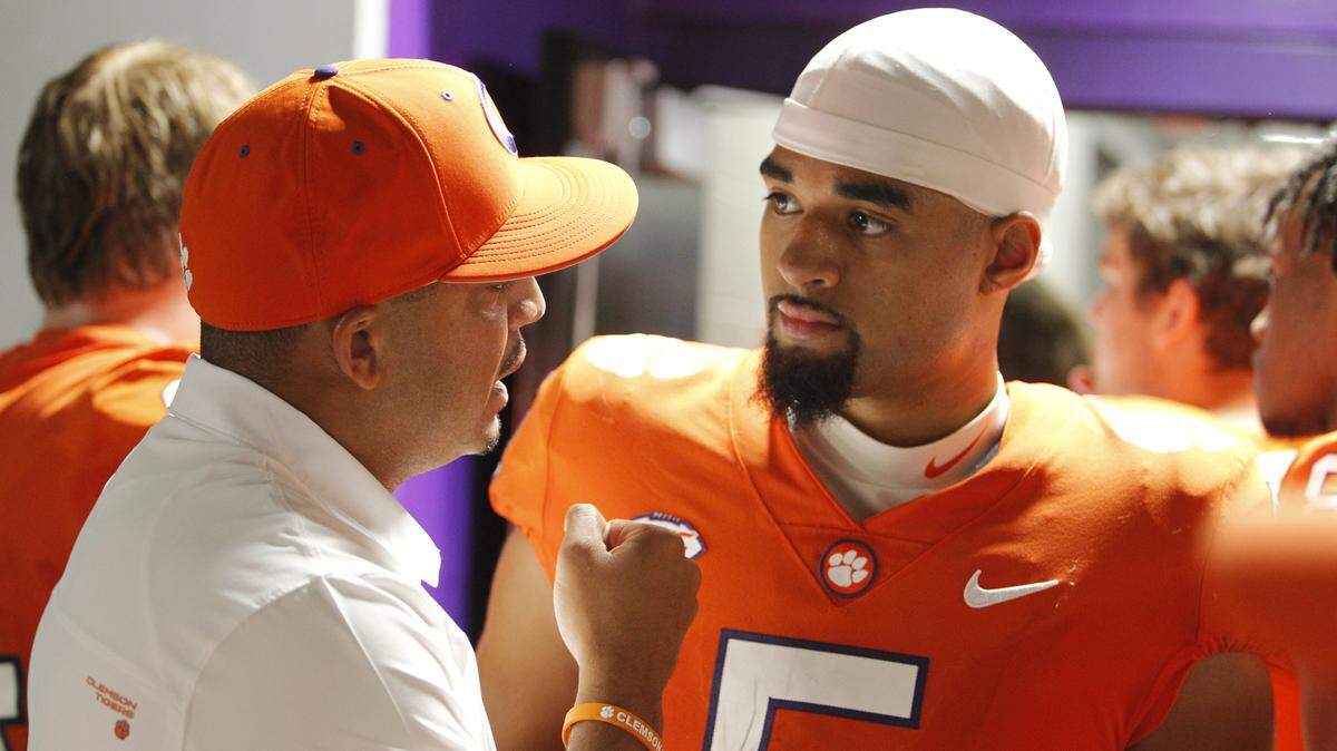 Clemson offensive coordinator Tony Elliott gives a few words of encouragement to quarterback D.J. Uiagalelei outside the locker room after the Tigers’ loss to Georgia at the Duke’s Mayo Classic in Charlotte, N.C. on Saturday, Sept. 4, 2021.