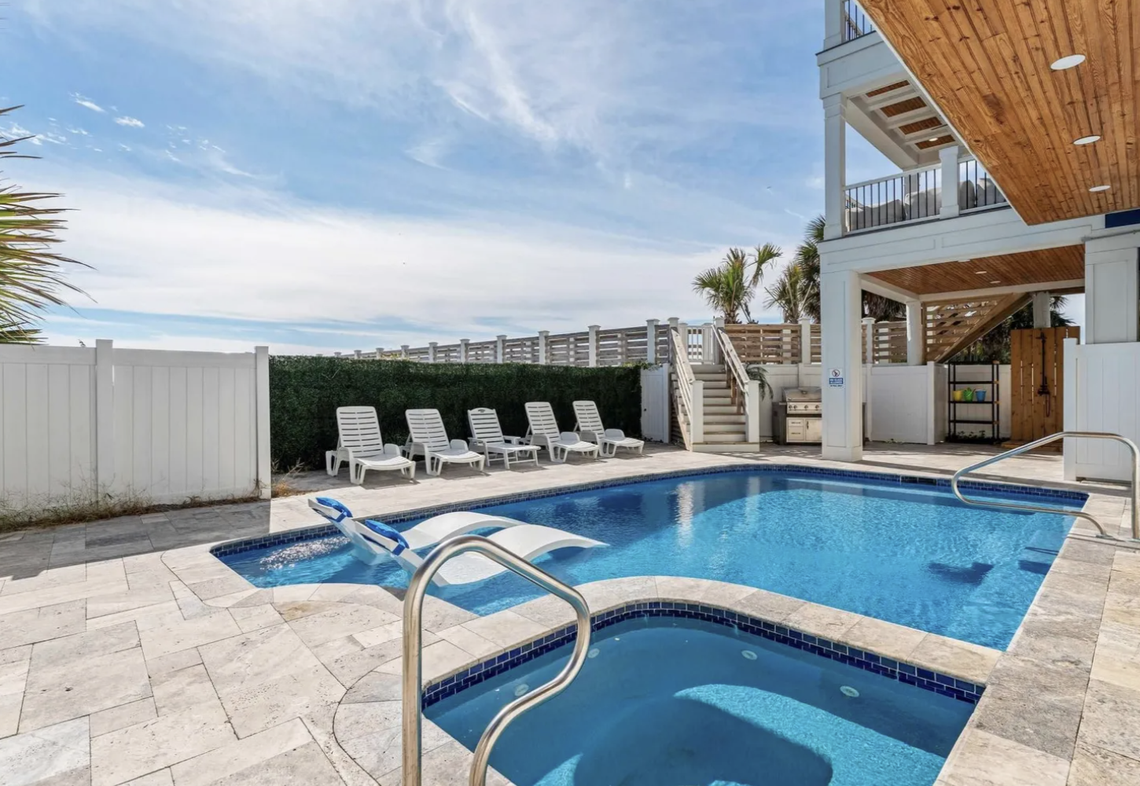 The in-ground pool is heated and has an adjacent hot tub.
