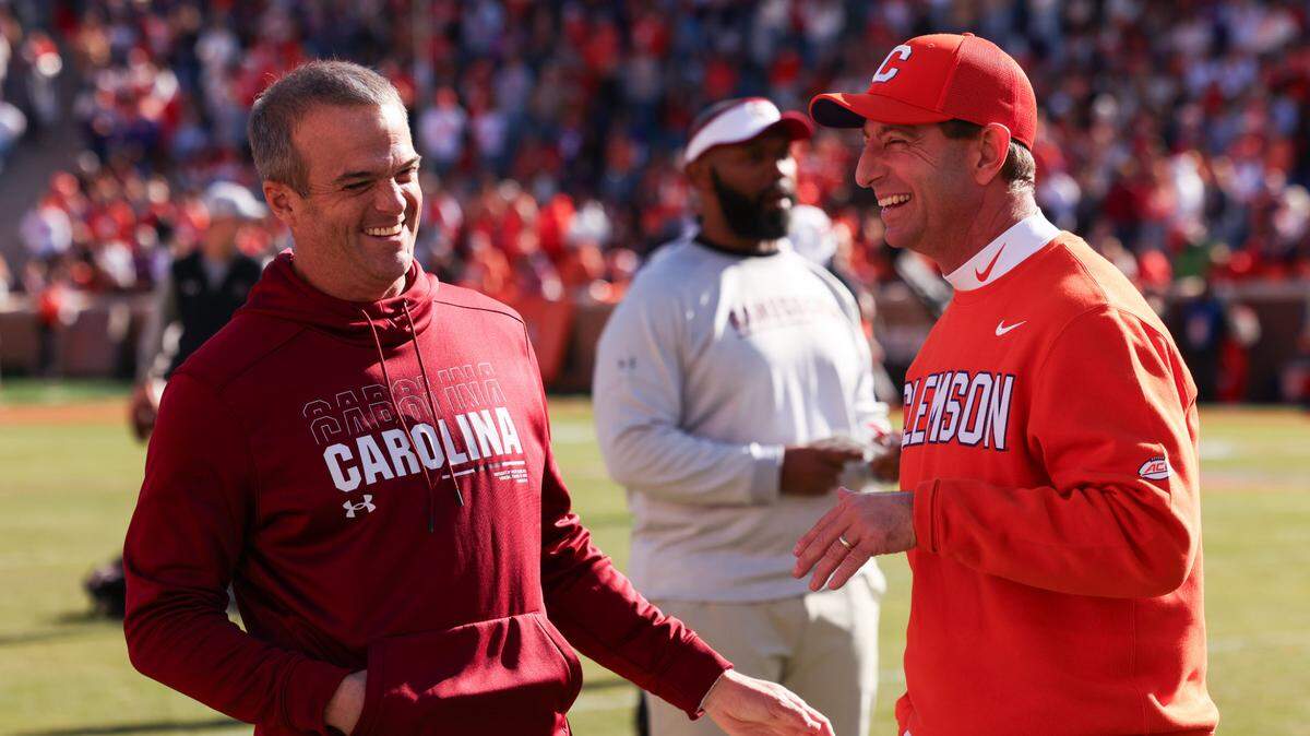 South Carolina head coach Shane Beamer laughs with Clemson head coach Dabo Swinney on the field before the Palmetto Bowl between at Memorial Stadium in Clemson on Saturday, November 30, 2024.