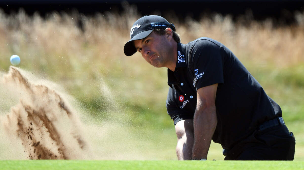 Kevin Kisner hits out of a green side bunker on the 18th green during the first round of The Open Championship golf tournament at Carnoustie Golf Links.